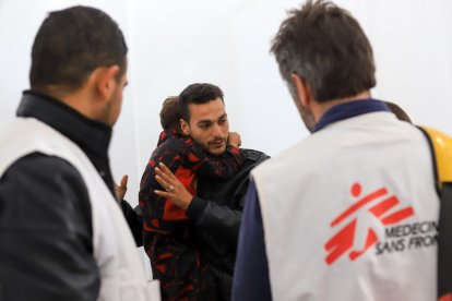 El equipo de MSF con un padre y su hijo (tiene una pierna lastimada), en el establecimiento de MSF, en Al Mawasi.