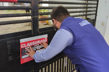 Funcionario de  la Agencia de Aseguramiento de la Calidad de los Servicios de Salud y Medicina Prepagada colocando el sello de clausura en uno de los tres establecimientos