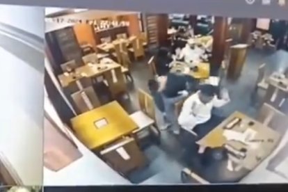 Aquí se observa al delincuente despojando de sus pertenencias a los comensales.