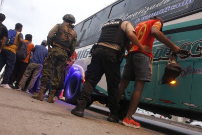 Los hombres de dos buses fueron bajados de los transportes para ser revisados.