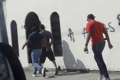 En un momento se observó que policías sacaron esposados a dos hombres.