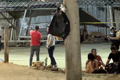 Familiares de uno de los fallecidos lloran junto a su cadáver en la cancha de ecuavóley.