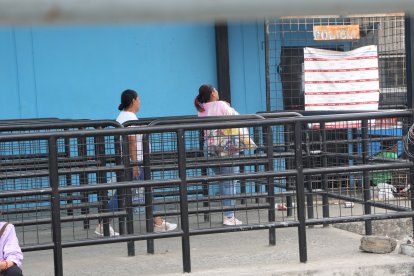 Una mujer busca la forma de hacer llegar una funda con comida a los presos.