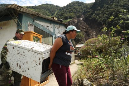 En Quilloturo, una afectada recoge lo que pudo salvar de su casa.