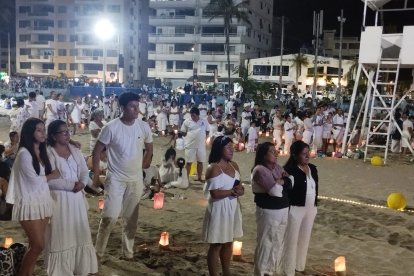 Feligreses esperan con velas en sus manos