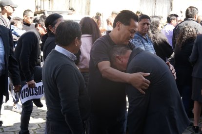 El padre de la oficial del ejército era consolado por un familiar.