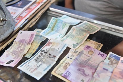 En su puesto tiene billetes de varios países. Obsequio de sus clientes.