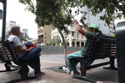 Ellos esperaban por un chance de trabajo en una banca frente al edificio.