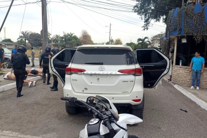 El carro blanco presenta varios impactos de proyectiles en la parte posterior.