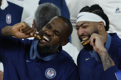 Jugadores de baloncesto de Estados Unidos muerden sus medallas.
