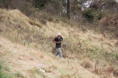 Una persona en situación de calle sale corriendo de entre la maleza.