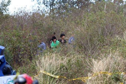 Miembros de la comunidad indígena buscaban pertenencias de las víctimas entre la maleza que hay cerca de la carretera.