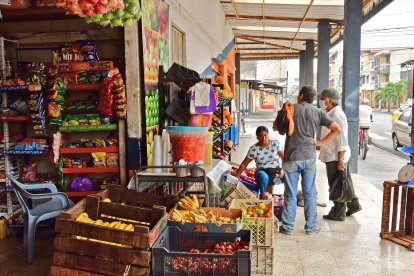 Dolores, por su parte, pela las cebollas y ordena los productos.