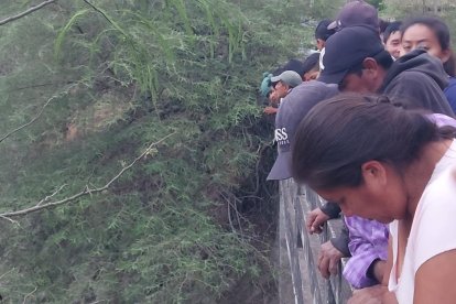 Las personas miraban el cadáver que estaba en el agua.