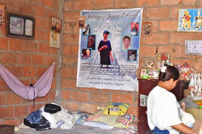 En una pared esta un cartel en homenaje al otro de los hijos, asesinado hace seis meses.