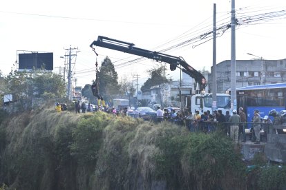 Los curiosos veían cómo intentaban extraer el carro de la quebrada.