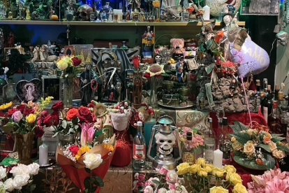 Los fieles adornan el colorido altar con todo tipo de ofrendas, desde botellas de licor hasta arreglos florales.