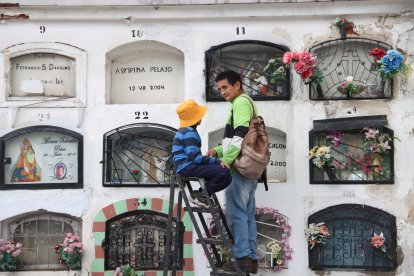 Padre e hijo visitan a un familiar en el cementerio de El Tejar.