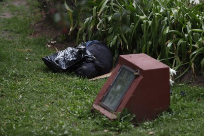 Un indigente, ‘cobijado’ con una funda de basura, permanecía en el jardín.