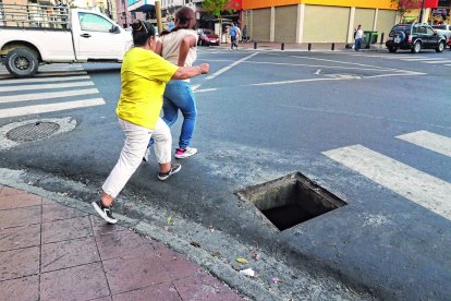 Ciudadanas cerca de caer en la alcantarilla por cruzar la calle.