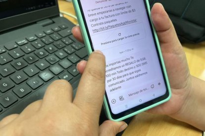 Una persona lee un mensaje que le ha enviado una telefónica sobre la compensación por los apagones que hay en Ecuador.