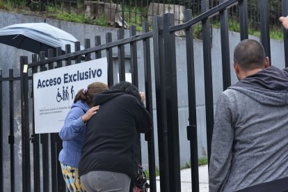 Doris Pinto (izquierda) consolaba a una mujer que perdió a su esposo. No la dejaban ingresar para verlo.