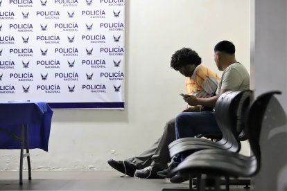 Uno de los sospechosos (el que aparece inclinado hacia adelante) en una unidad policial.