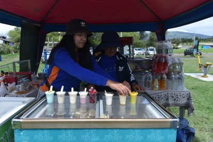 Una nieta política le ayuda en la venta en el parque.