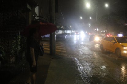 Ciudadanos se protegían de la lluvia de este martes.