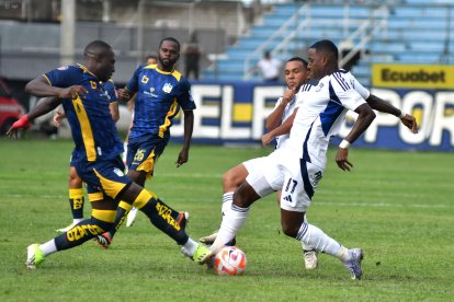 Jaime Ayoví (d), delantero de Emelec, disputa una pelota con un rival del Delfín.