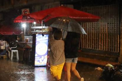 Guayaquileños se protegían de la lluvia de este 22 de febrero por la noche.