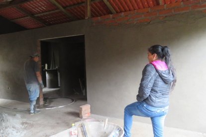 María Guamán mira y contribuye en la construcción de la que será u casa, como parte de las residencias donadas.