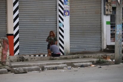 Alrededor del cuerpo, dos mujeres y un hombre se mantuvieron pendientes y hablando por teléfono.