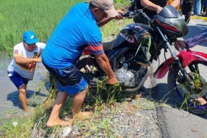 Vecinos y policías colaboraron para sacar el cuerpo de la fémina del arrozal.