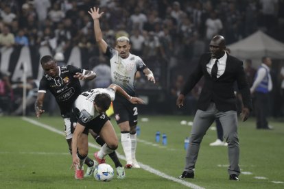 Ángel Romero (c) de Corinthians disputa el balón con Aníbal Chalá (i) de Barcelona en un partido de la tercera ronda de la Copa Libertadores.