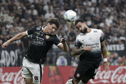 Memphis Depay (d) de Corinthians disputa el balón con Gastón Campi de Barcelona.