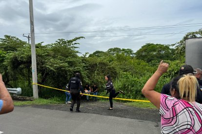 Agentes de la DINASED recogen indicios en el lugar donde fueron hallados los cuerpos.