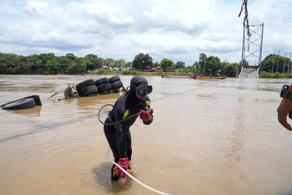 Buzos ayuda en la tarea de ubicación de los vehículos que cayeron con la estructura colgante