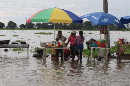 Comerciantes calman el hambre de quienes esperan que baje la marea.