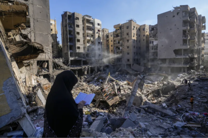 Una mujer lee el Corán en el lugar donde fue asesinado el líder de Hezbollah, Hassan Nasrallah, el domingo 29 de septiembre de 2024, en los suburbios al sur de Beirut.