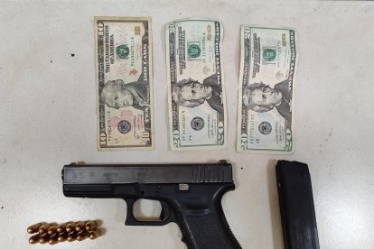 Entre las evidencias consta, un arma, municiones y dinero.