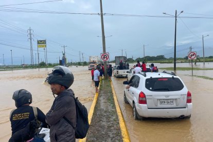 Conductores esperan que baje el caudal para poder cruzar.