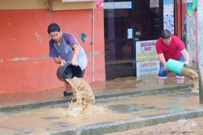Con baldes sacaban el agua y el lodo que se metió a los locales.
