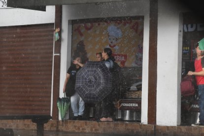 La gente espera debajo de los techos para ir a sus hogares.