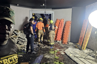 El personal de Defensa Civil y bomberos inspeccionando la discoteca Jet Set tras el derrumbe.