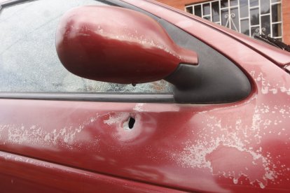 Un vehículo que estaba estacionado cerca quedó con orificios por los impactos de proyectiles.