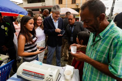Guillermo Lasso mientras emplasticaba su certificado de votación.