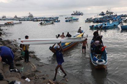 Los miembros de la Fundación Aparicio Pérez cuando sacaban la yola de las aguas en Posorja, tras quedar fuera de competencia por avería.
