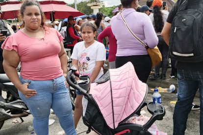 Joselyne Chávez junto a sus dos niñas, aguardando por el reclutamiento de su familiar.