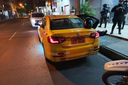 La policía llegó al sitio del suceso para recabar indicios. Uno de los cuerpos quedó del taxi.